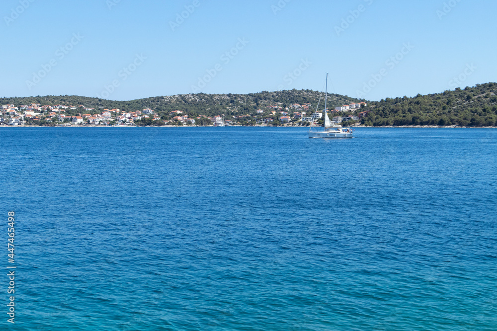 Sailing boat on the path to the Rogoznica Marina located safe, deep in the blue bay of Adriatic sea