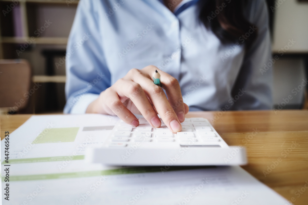 Business woman using calculator to review balance sheet annual using document to calculating budget. audit and Check integrity before investment concept. Business woman using calculator to review balance sheet annual using document to calculating budget. audit and Check integrity before investment concept.