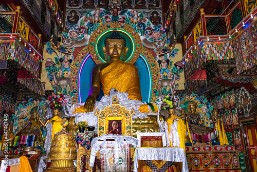 huge buddha golden statue decorated with religious flags and offerings at evening © explorewithinfo