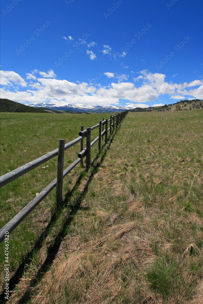 Round rail fence under blue sky in the Bighorn Mountain range in the Rocky Mountains near Buffalo Wyoming USA