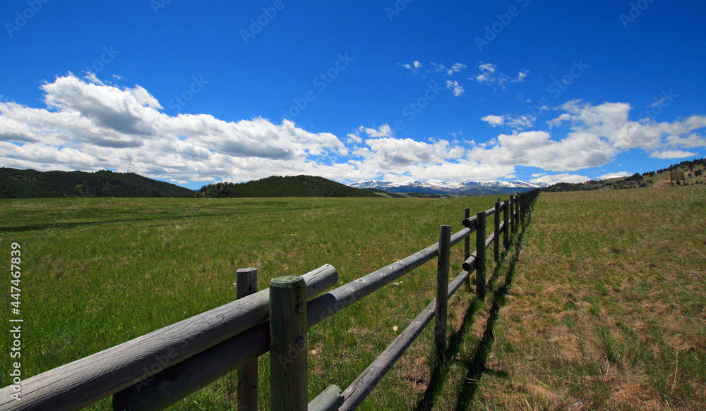 Round rail fence under blue sky in the Bighorn Mountain range in the Rocky Mountains near Sheridan Wyoming USA