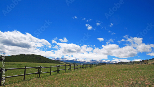 Round rail fence under blue sky in the Bighorn Mountain range of Rocky Mountains in Wyoming USA