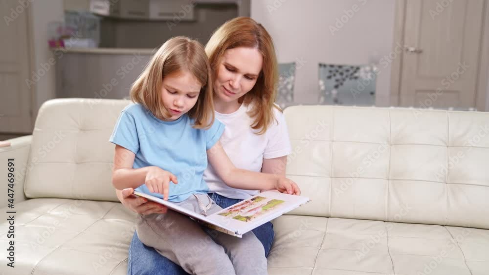 mother and daughter watch photobook family photo shoot in spring garden