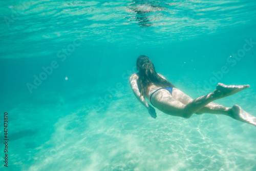 An underwater view of a girl swimming