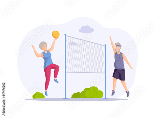 Happy elderly couple playing volleyball at summer park hitting to ball enjoying healthy lifestyle