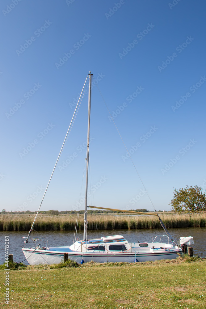 Sailing boat. Small white generic yacht moored on the Norfolk Broads UK
