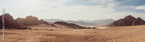 Panel kuchenny z motywem Safari and travel to Africa, extreme adventures or science expedition in a stone desert. Sahara desert at sunrise, mountain landscape with dust on skyline, hills and traces of the off-road car.