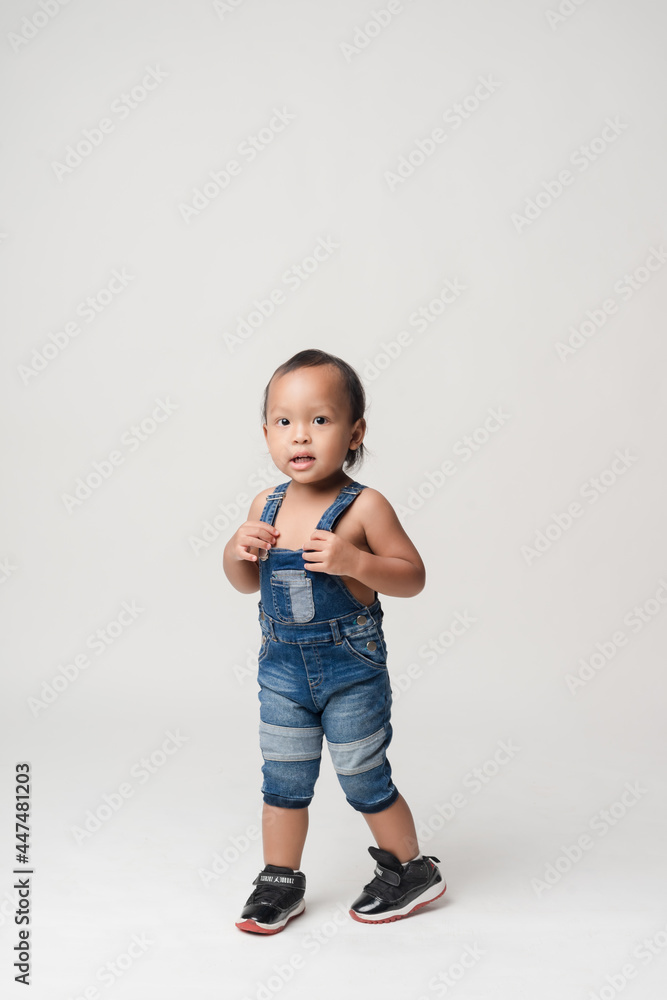 Asian boy wearing denim overalls is walking. Asian boy wearing denim overalls is walking.