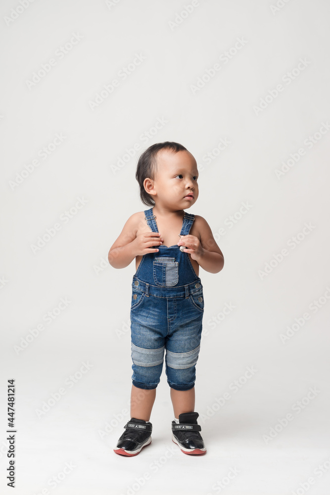 Asian boy wearing denim overalls is walking. Asian boy wearing denim overalls is walking.