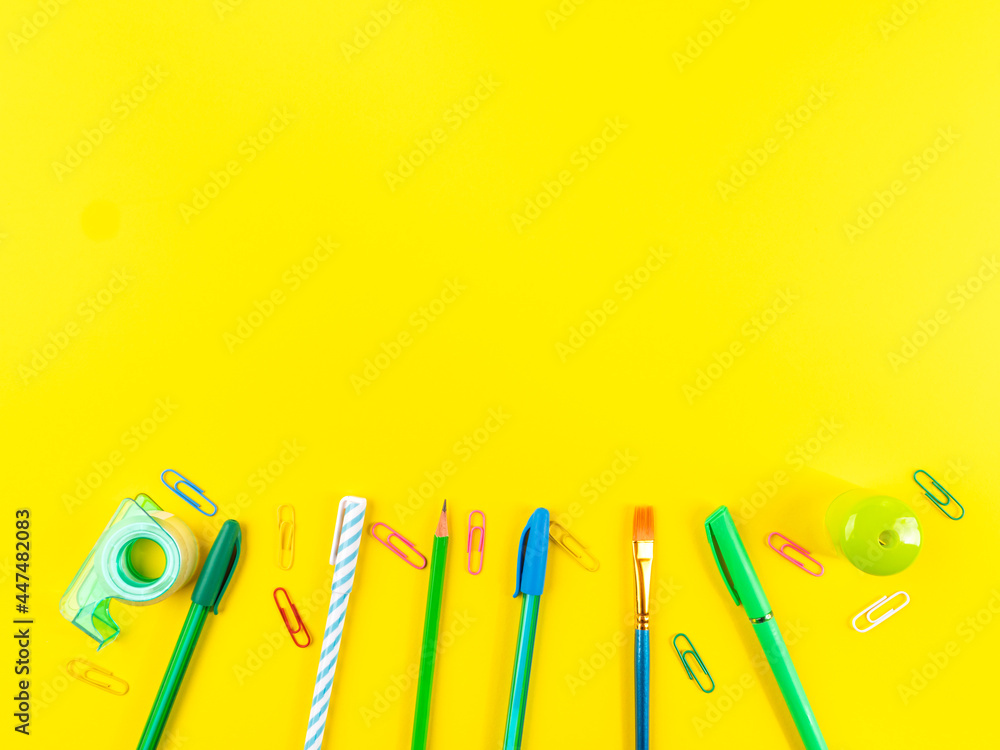 Back to school concept. Colorful writing tools on yellow background Back to school concept. Colorful writing tools on yellow background