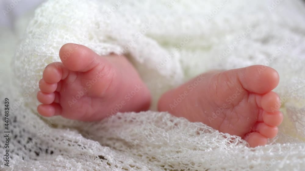 Close up the leg of newborn baby boy in white fabric Close up the leg of newborn baby boy in white fabric