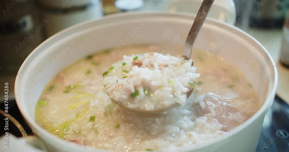 close up cooking stirring and holding Thai style food hot soft boiled rice with Pork Ribs at the kitchen, breakfast healthy food concept close up cooking stirring and holding Thai style food hot soft boiled rice with Pork Ribs at the kitchen, breakfast healthy food concept