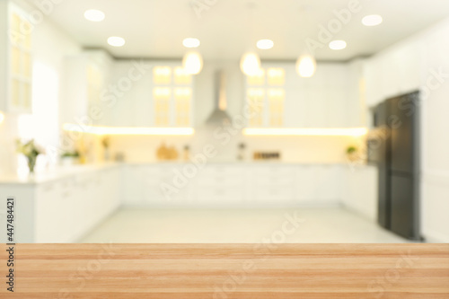 Empty wooden table and blurred view of stylish kitchen interior. Mockup for design