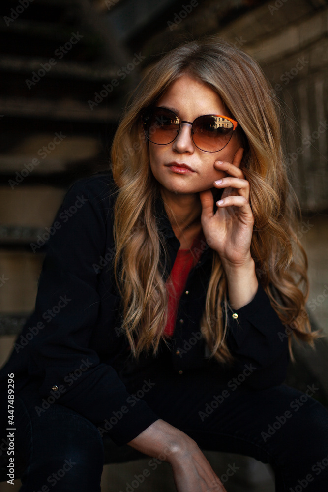 Girl in black clothes and glasses on the stairs Girl in black clothes and glasses on the stairs