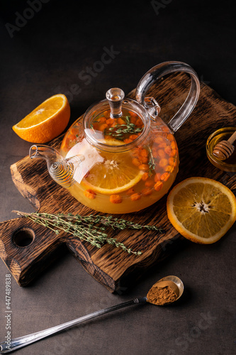 selective focus, freshly brewed sea buckthorn tea in a transparent teapot, with fruits and fresh berries. leaf tea and spices. still-life. for advertising and menus