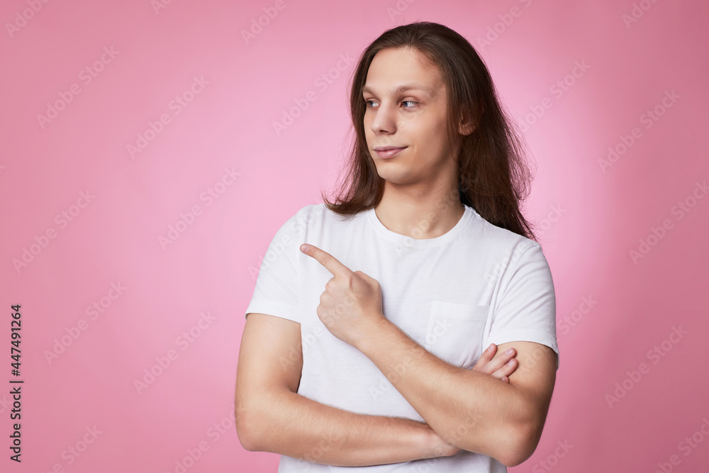 young man pointing finger away at empty space young man pointing finger away at empty space