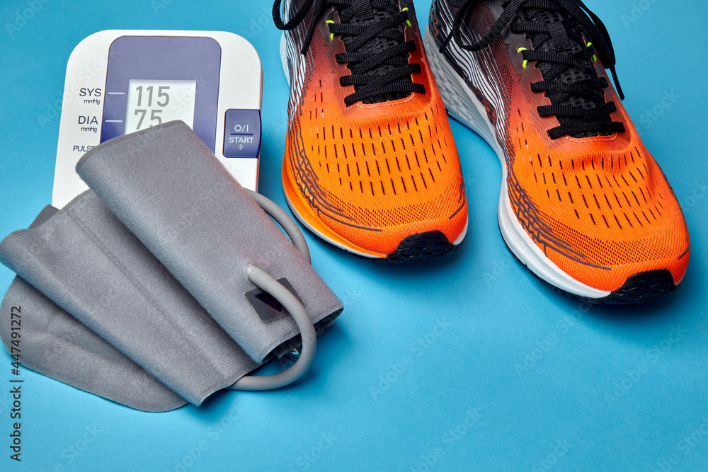 Sneakers and blood pressure monitor on a blue background Stock Photo |  Adobe Stock