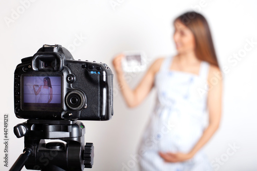 Women's blog. A young pregnant woman blogger shoots a video on camera about pregnancy.