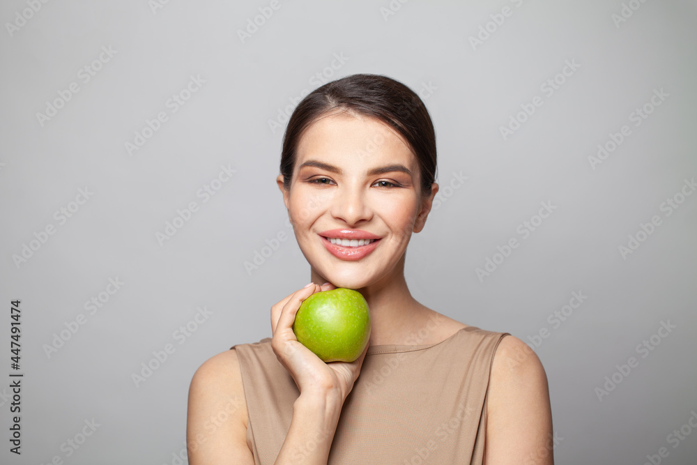 Smiling woman with healthy teeth holding green apple Smiling woman with healthy teeth holding green apple