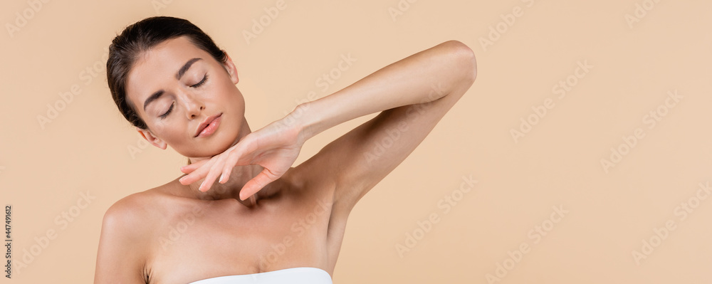 Obraz premium sensual woman with closed eyes holding hand near chin isolated on beige, beauty concept, banner