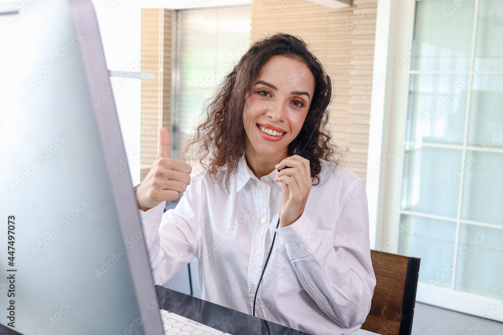 Smiling beautiful woman with headphones give thumb up at call center service desk consultant, call center agent with headset talk with customer online, operator with hands-free phone has conversation Smiling beautiful woman with headphones give thumb up at call center service desk consultant, call center agent with headset talk with customer online, operator with hands-free phone has conversation