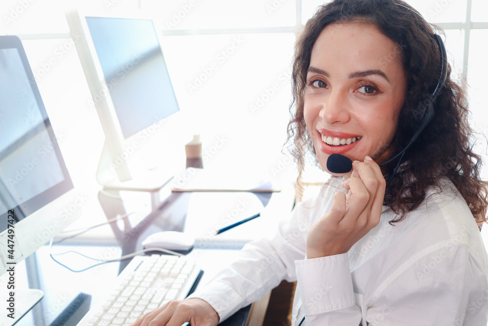 Smiling beautiful woman with headphones work at call center service desk consultant, call center agent with headset talk with customer on hotline, operator with hands-free phone has conversation. Smiling beautiful woman with headphones work at call center service desk consultant, call center agent with headset talk with customer on hotline, operator with hands-free phone has conversation.