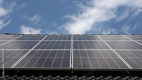 Time lapse of cloud reflections on solar panels on a black tile roof
