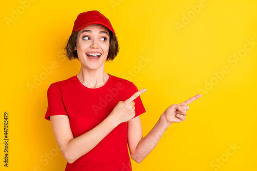 Photo of nice impressed brown hair lady point empty space wear t-shirt cap isolated on yellow color background