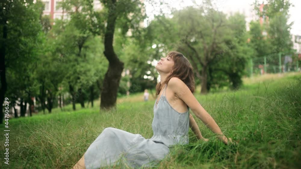 Portrait of young beautiful woman sitting on grass, on green background summer nature. Calm girl enjoy smile and relax in spring city air. Portrait of young beautiful woman sitting on grass, on green background summer nature. Calm girl enjoy smile and relax in spring city air.