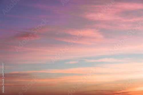 A cloudy landscape with pink clouds at a sunset.