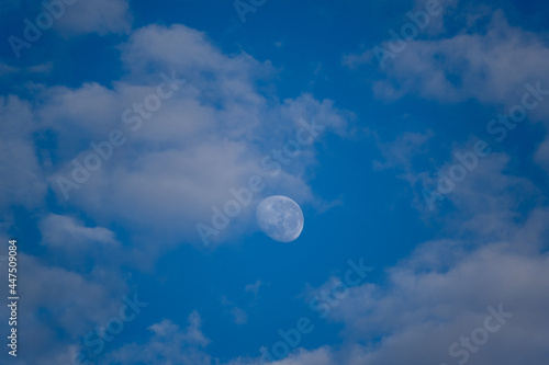 Lua entre as nuvens e céu azul da manha