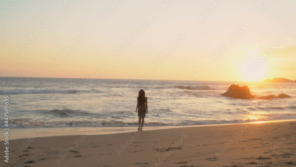 Portrait of a young dark-haired woman walking around the ocean on the background of the sea at sunset. Portrait of a young dark-haired woman walking around the ocean on the background of the sea at sunset.