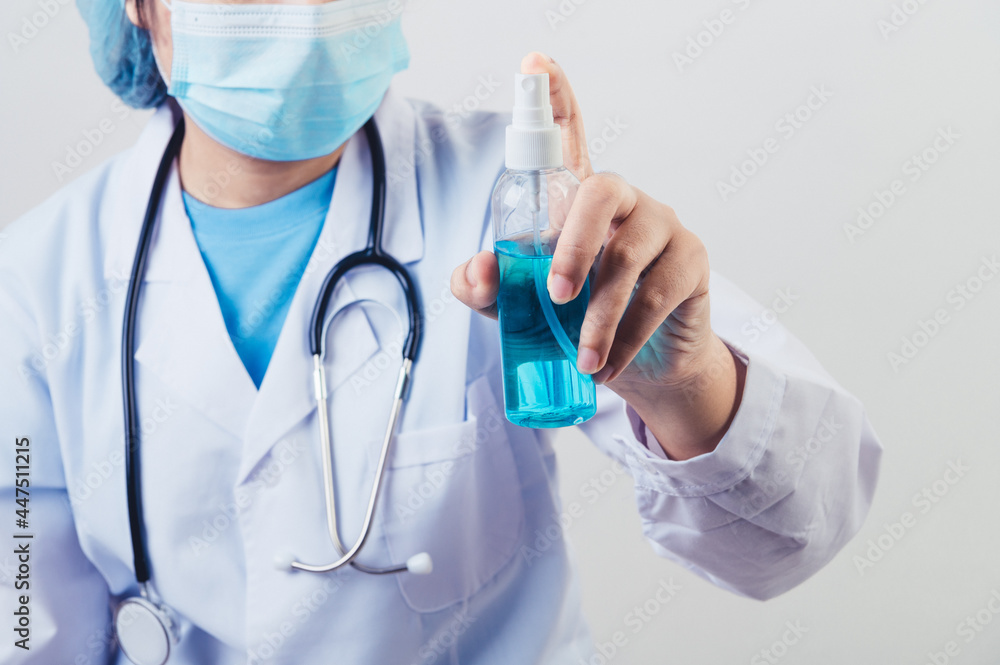 Doctor sprays hand sanitizer or gel dispenser to clean hands and kill viruses and bacteria into the air after patients visited. Medical health people and illness protective concept. Doctor sprays hand sanitizer or gel dispenser to clean hands and kill viruses and bacteria into the air after patients visited. Medical health people and illness protective concept.
