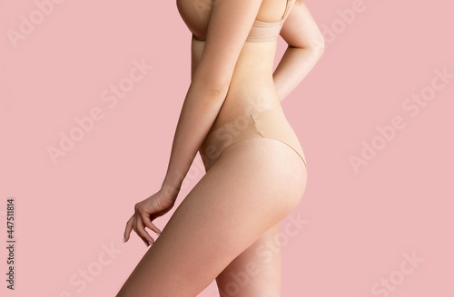 Crop image of young woman in lingerie isolated over pink studio background. Beauty, fitness, diet, sports, plastic surgery and aesthetic cosmetology concept.
