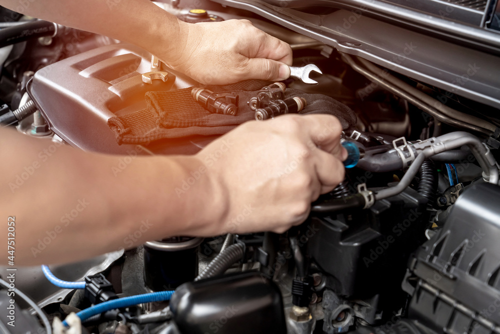 Technician use wrench and screwdriver removing the gasoline injector part on engine maintenance concept check and service Technician use wrench and screwdriver removing the gasoline injector part on engine maintenance concept check and service