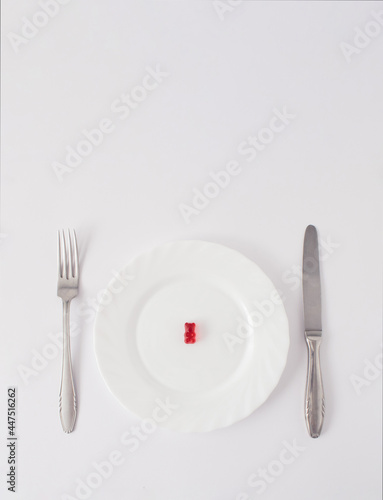 Red gummy bear served on plate. minimal creative concept on  white background.