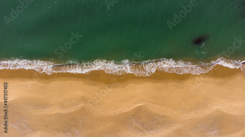 Aerial top down view of soft splashing waves at the beach photo