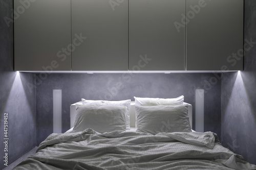 Hotel room with white cupboards and comfort bed