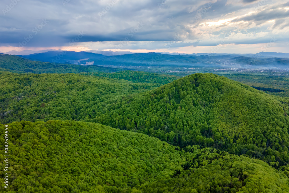 Aerial view of dark mountain hills covered with green mixed pine and lush forest in evening. Aerial view of dark mountain hills covered with green mixed pine and lush forest in evening.