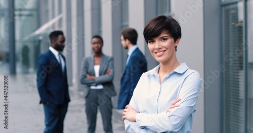 Portrait of beaming young caucasian businesswoman wearing formal clothes standing arms crossed at the street and looking at the camera. People and career concept Free Download Portrait of beaming young caucasian businesswoman wearing formal clothes standing arms crossed at the street and looking at the camera. People and career concept - GFXLoad