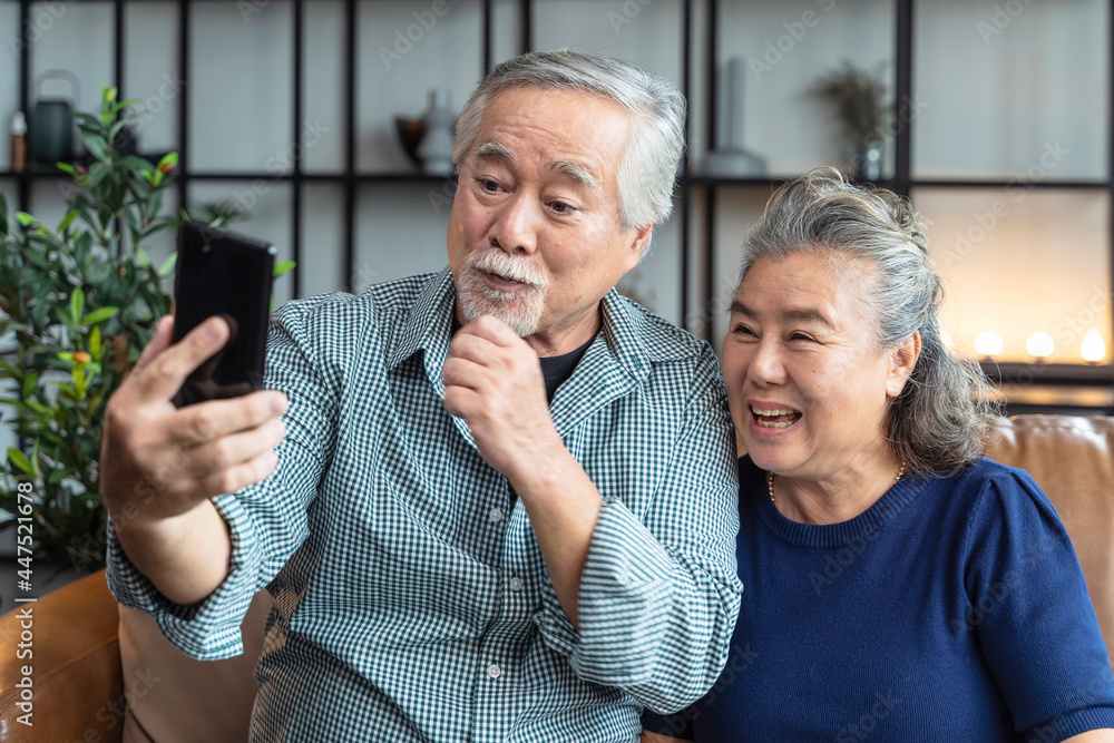 happiness asian old senior retired couple enjoy videocall to family together on sofa in living room at home,asian people use smartphone communication to family home isolation ides concept - obrazy, fototapety, plakaty 