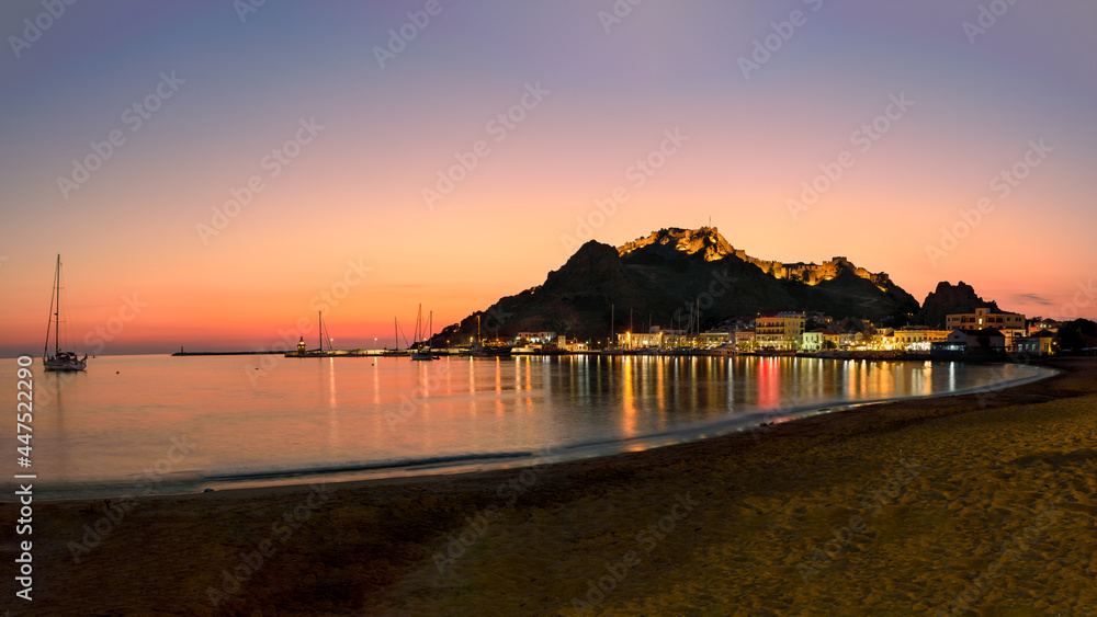 The illuminated castle and the old port of Myrina on the island of Lemnos at golden hour.