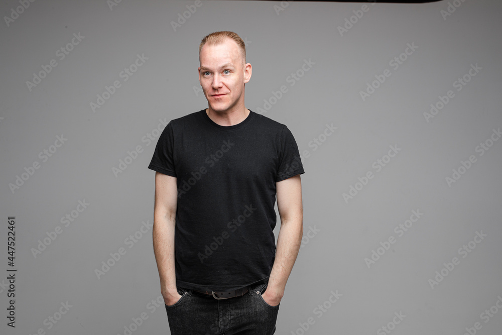 portrait of caucasian man with short fair hair keeping hands in the pockets and smiles portrait of caucasian man with short fair hair keeping hands in the pockets and smiles