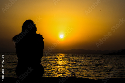 silhouette of a person on the lake at sunset