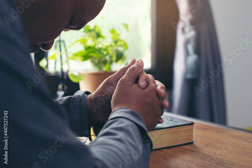 Prayer and bible concept. Asian senior man praying  hope for peace the world and free from coronavirus  Hand in hand together  believes and faith in christian religion at home.