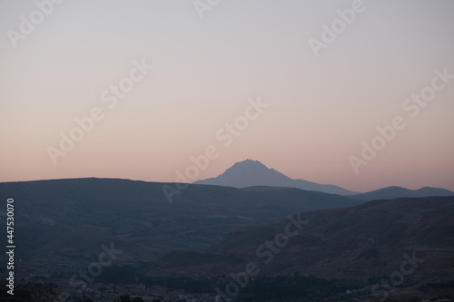 Mountain peak of Erciyes by taking photo from chimneys of Three beauties (uc guzeller) in Cappadocia early in the morning during sun rise