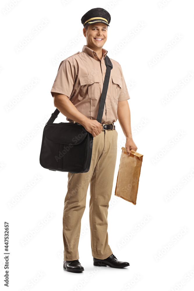 Full length portrait of a smiling mailman in a uniform carrying a bag and a package