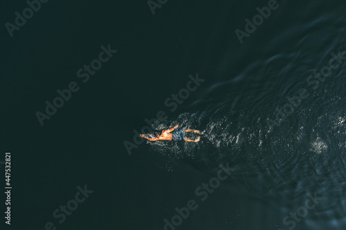 Fototapeta Naklejka Na Ścianę i Meble -  Man with a beautiful body swims in the lake