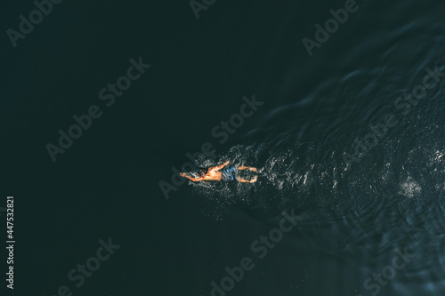 Man with a beautiful body swims in the lake