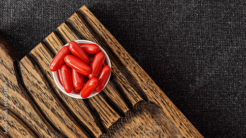 ubiquinol supplement softgels on a wooden desk. dietary supplements top view. mental wellbeing and personal health concept